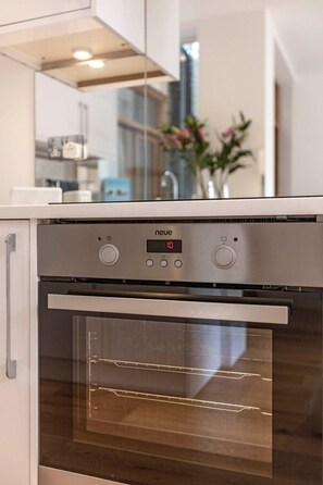 Une cuisine moderne dotée d’un four encastré et d’un panneau de commande numérique.