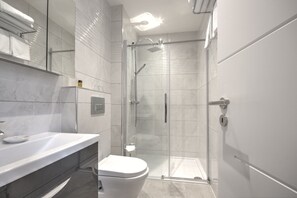 A modern bathroom with a glass-enclosed shower, a white toilet, and a marble-tiled vanity. - Beautiful House Close to Inverness City Centre (Inverness)
