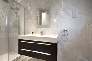 Huis | Badkamer | Een douche, een haardroger, handdoeken