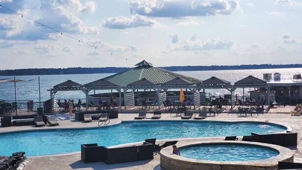 Une piscine avec des chaises longues et un kiosque.
