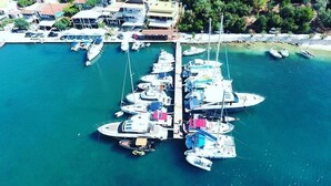 An aerial view of a marina with multiple boats docked at a pier. - Villa Skorpios (lefkada)