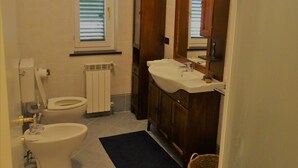 A bathroom with a toilet, sink, and window. - Gorgeous apartment with large sea view terrace (Civezza)