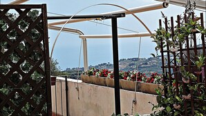 A rooftop garden with metal structures and potted plants. - Gorgeous apartment with large sea view terrace (Civezza)
