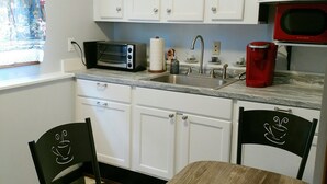 A compact kitchen with white cabinets, a microwave, a red coffee maker, and a checkered floor. - A quiet place near Ithaca, Ithaca College & Cornell. (Danby)