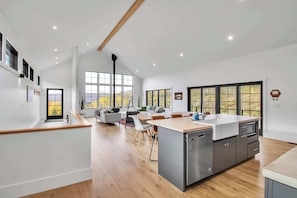 A modern kitchen with a central island, built-in appliances, and large windows.