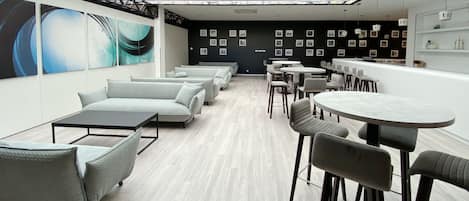 A modern interior with a glass ceiling, light-colored flooring, and a mix of sofas and tables.