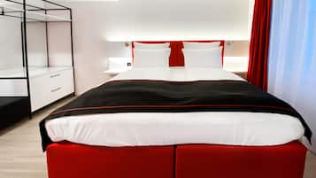 Ein modernes Hotelzimmer mit einem großen Bett, einem Kleiderschrank und einem Nachttisch.