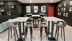 A conference room with a long table, multiple chairs, and artwork on the walls. - DORMERO Hotel Hersbruck (Hersbruck)