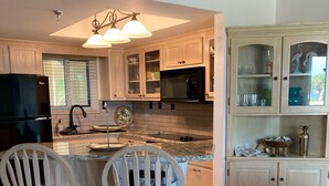 A modern kitchen with two bar stools, a microwave, and a Samsung refrigerator.