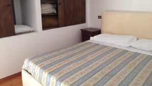A bedroom with a bed, a wardrobe, and a small bedside table. - CASA PETRA - OPEN SPACE (brindisi)