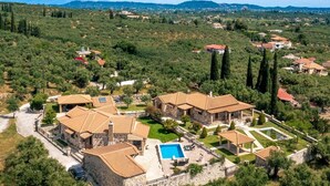 Un ensemble de villas comprenant plusieurs bâtiments, une piscine et un jardin bien entretenu.