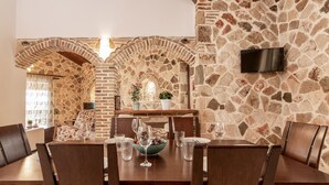 Un coin repas avec un mur en pierre, une table en bois et des chaises.