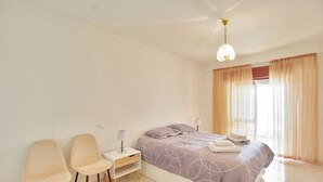 A bedroom with a bed, two chairs, a nightstand, and a lamp. - Prestige For Home - 2 bedroom apartment - Lagos (Lagos)