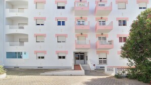 A multi-story building with balconies, a central entrance, and a paved courtyard. - Prestige For Home - 2 bedroom apartment - Lagos (Lagos)