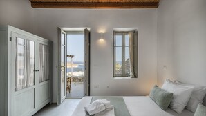 A bedroom with a bed, a wardrobe, and a window with a view of the sea. - Infinity Villa, luxury house with stunning view in Serifos (Serifos)