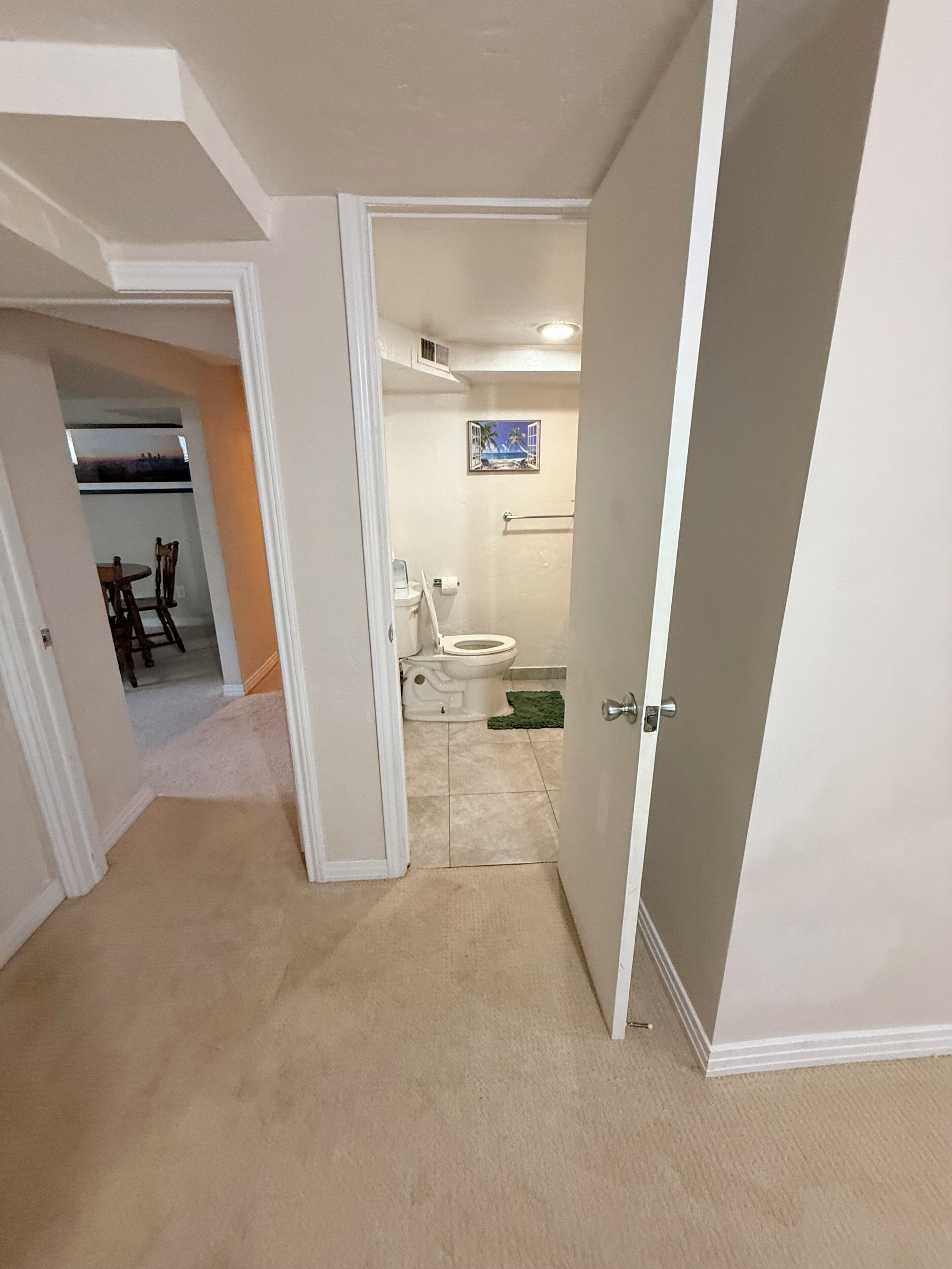 A bathroom with a toilet, sink, and a towel rack.