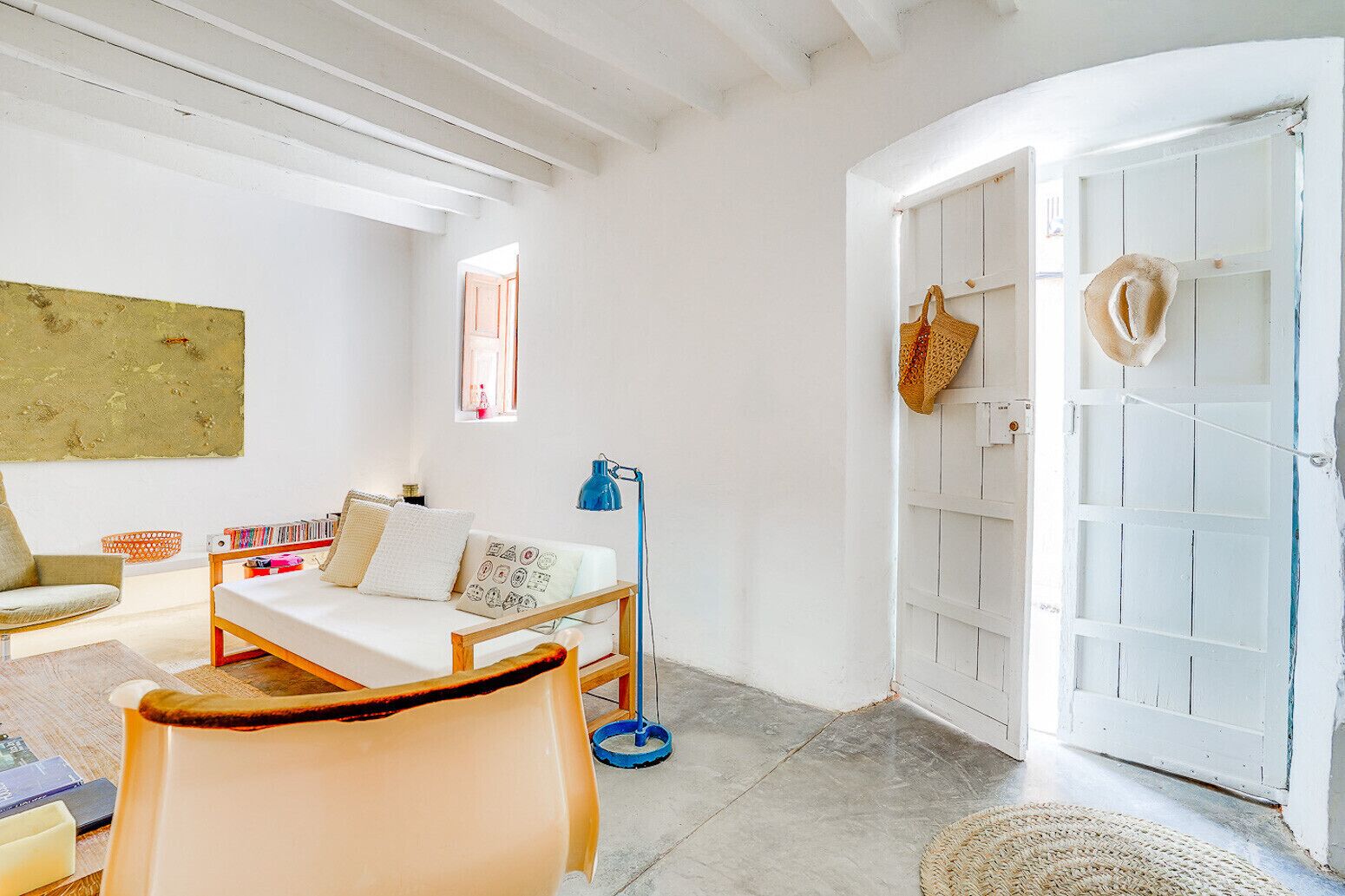 A cozy room with a bed, a chair, a desk, and a bookshelf.
