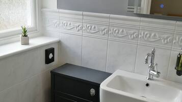 A bathroom with a toilet, sink, and cabinet.