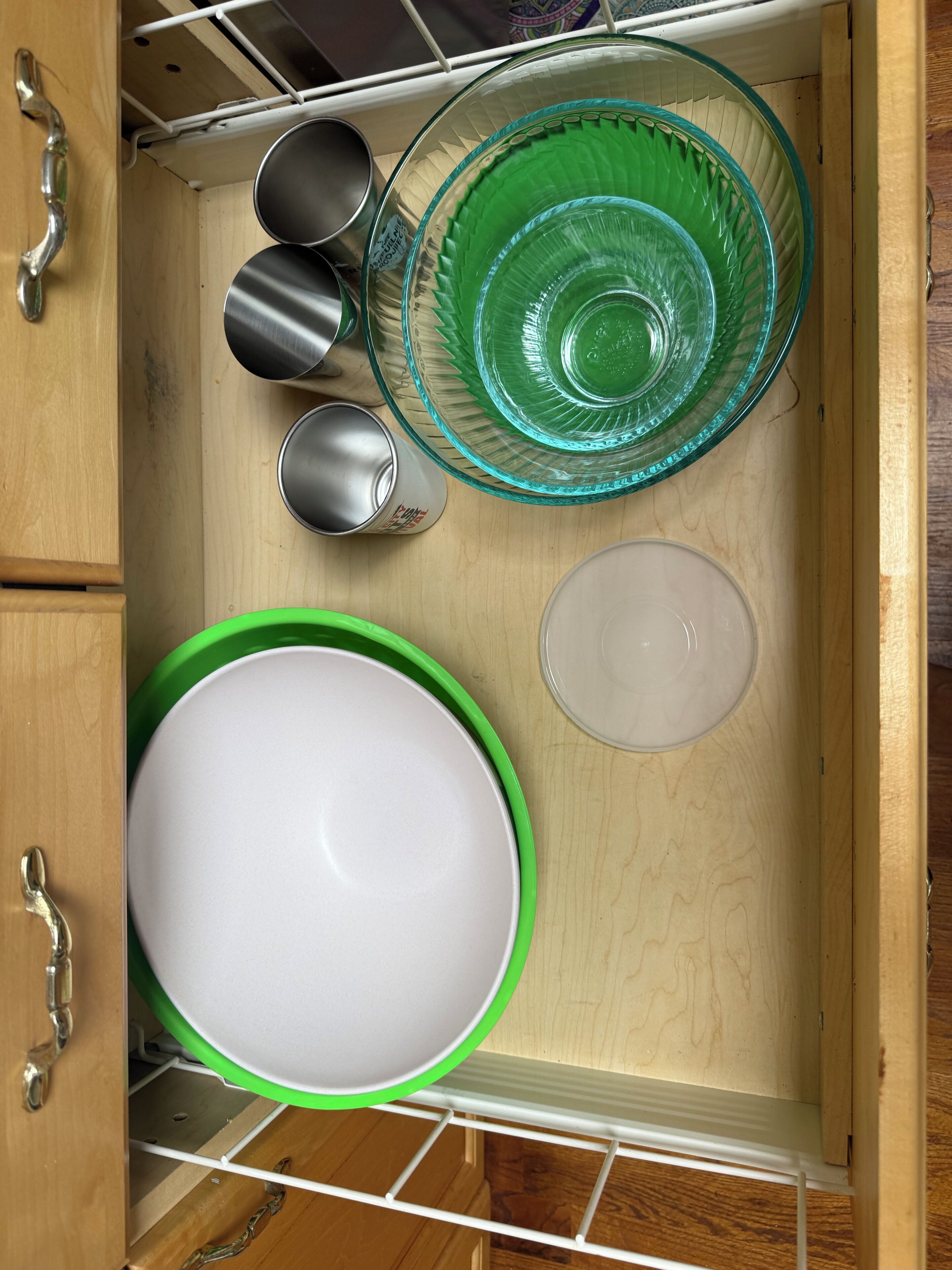 Un meuble de cuisine contenant un égouttoir à vaisselle avec divers plats et ustensiles de cuisine.