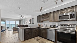 A modern kitchen with dark cabinets, stainless steel appliances, and a large island. - Direct Oceanfront View from Nearly Every Room! Great Getaway Near No-Drive Beach (New Smyrna Beach)