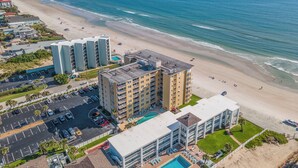 A coastal hotel with multiple buildings, a parking lot, and a beach. - Direct Oceanfront View from Nearly Every Room! Great Getaway Near No-Drive Beach (New Smyrna Beach)
