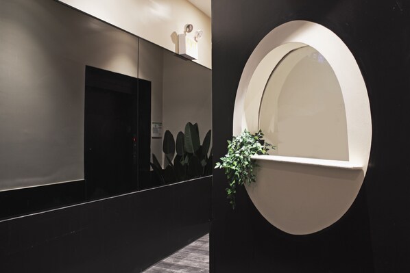 Reflect on serenity in this stylish space, featuring a large mirror and lush greenery.
