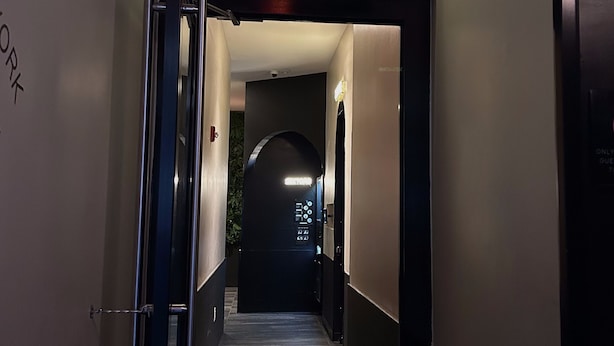 Un pasillo con un cartel que dice 'NAP YORK' que lleva a una habitación.