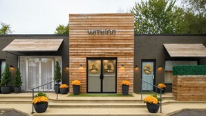 A modern hotel with a wooden facade, a double door entrance, and potted plants on the steps. - Escape WithInn-Relaxation Centrally Located to Beaches and Walkable Restaurants (Harbert)