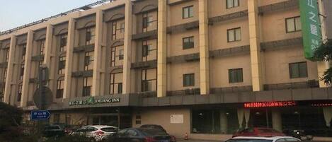 A multi-story hotel with a sign indicating it is a Jinyang Inn.