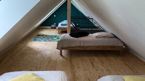 A room with two beds, wooden flooring, and a sloped ceiling. - Longere LE Penty - Plougonvelin (Plougonvelin)