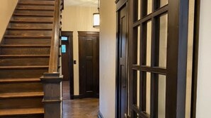 Una escalera de madera con barandilla y una lámpara colgante.