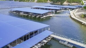Een perceel aan het water met meerdere overdekte steigers en een ruim open dek.