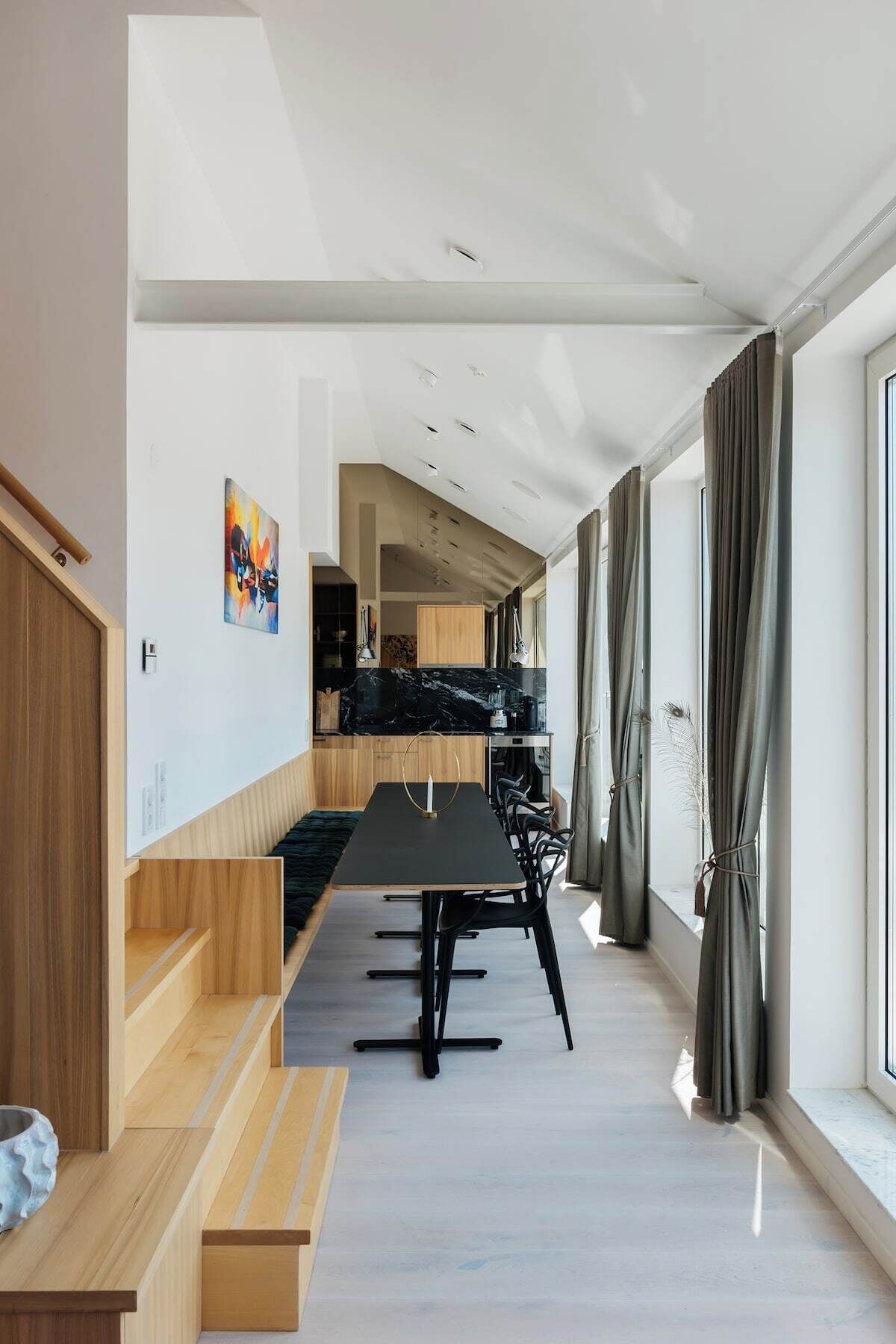 A modern kitchen with dark countertops and a black dining table.