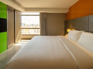 A hotel room with a large bed, a TV, a window with a city view, and a modern design. - Check Inn Select Hualien Linsen (Hualien City)