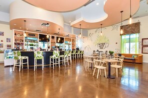 A coffee bar with seating and a bar counter, surrounded by wooden chairs and tables.