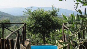 A stone pathway leading to a swimming pool with a view of a mountainous landscape. - Farmhouse in the greenery of the Tuscany countryside with private pool and view (Murlo)