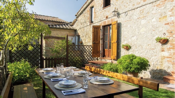 A wooden table set outdoors with plates, glasses, and a bench. - Farmhouse in the greenery of the Tuscany countryside with private pool and view (Murlo)
