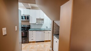 A kitchen with white cabinets, a microwave, an oven, and a dishwasher.