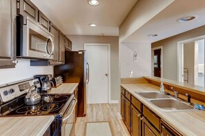 A modern kitchen with stainless steel appliances, wooden cabinets, and a double sink. - Lake Dillon! Ampitheatre, Walk to Lake,Pool&HT (Dillon)