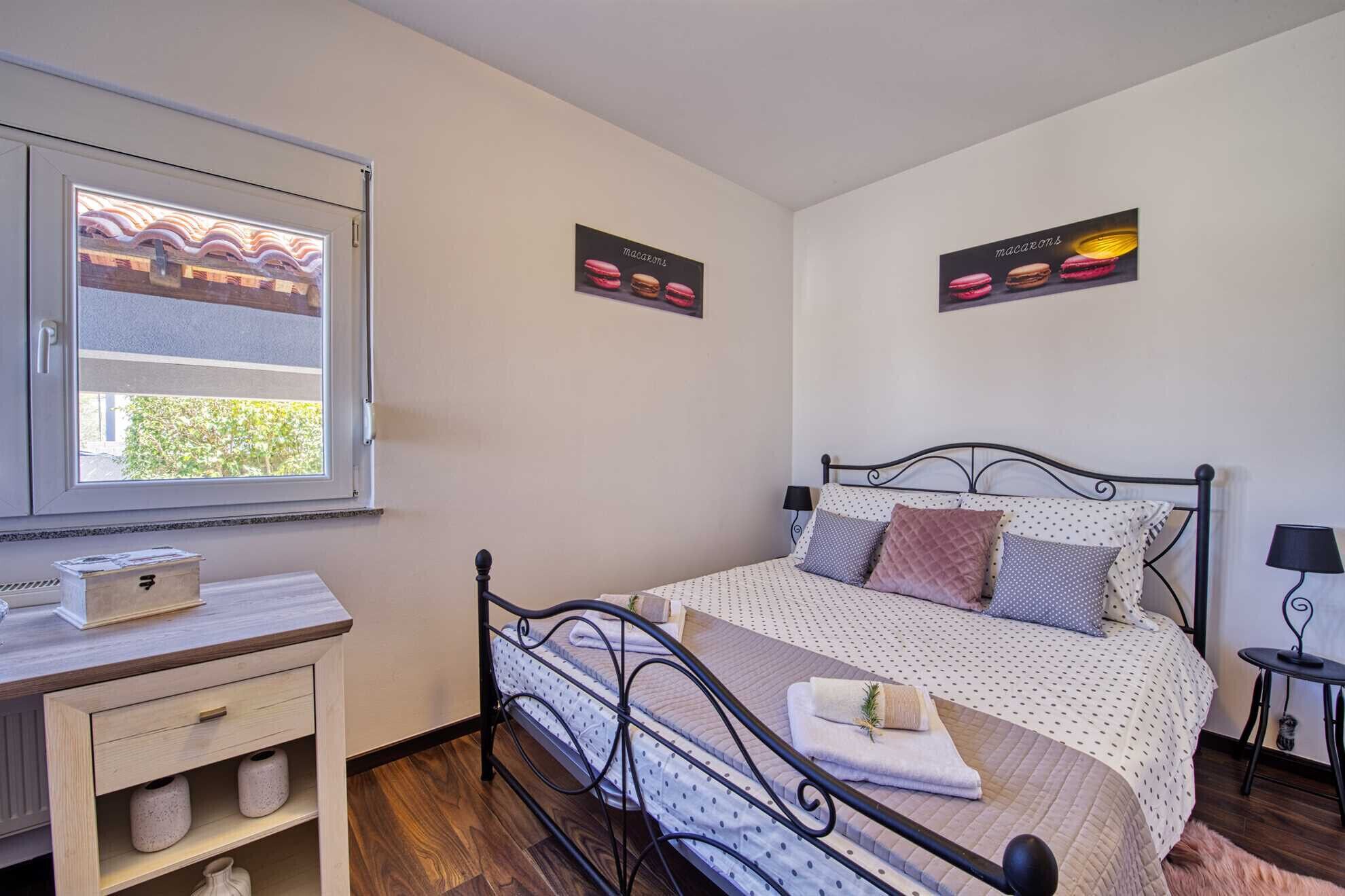 Quarto com uma cama, escrivaninha e janela.