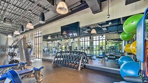 A gym with various exercise equipment, including dumbbells, treadmills, and exercise balls.