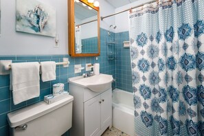 Une salle de bain avec un lavabo, un miroir et des murs recouverts de carreaux bleus.