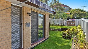 A residential property with a brick exterior, a metal gate, and a small garden.
