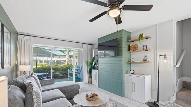 Un salon moderne avec un canapé, une table basse et un ventilateur de plafond.