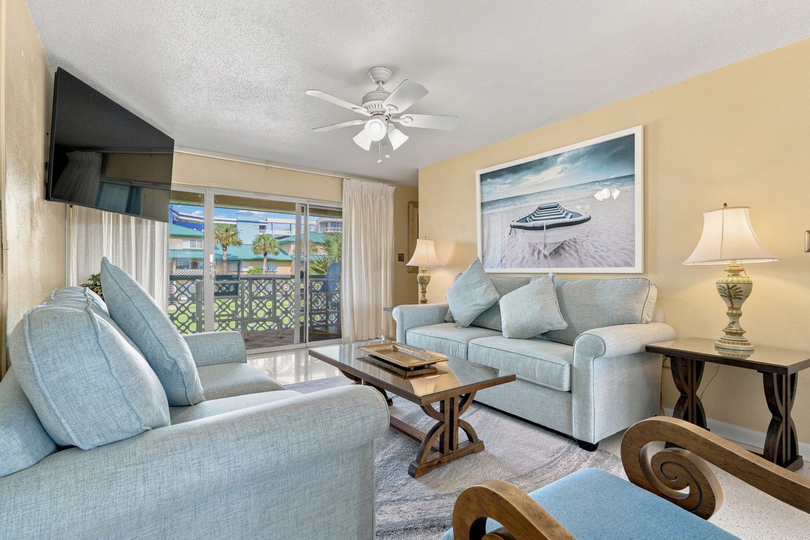A living room with a sofa, coffee table, and a ceiling fan.