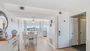 A bright hallway with a dining area, white walls, and a ceiling fan. - Seaspray Condos - 114C (Fort Walton Beach)