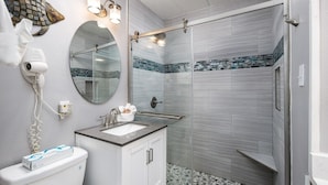 A bathroom with a toilet, sink, and shower.