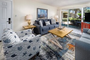 Ein Wohnzimmer mit Sofa, Sesseln, Couchtisch und einem Bild an der Wand.