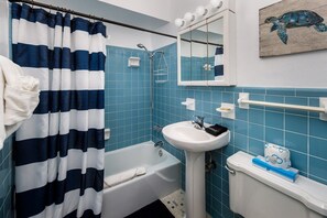A bathroom with a bathtub, a sink, and a toilet.