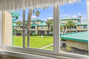 A hotel with a view of a well-maintained lawn and multiple buildings with green roofs. - Seaspray Condos - 207A (Fort Walton Beach)